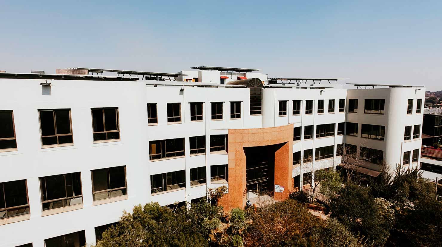 Oppenheimer: the white four storey office facade and stone clad entrance portal, photographed during construction.