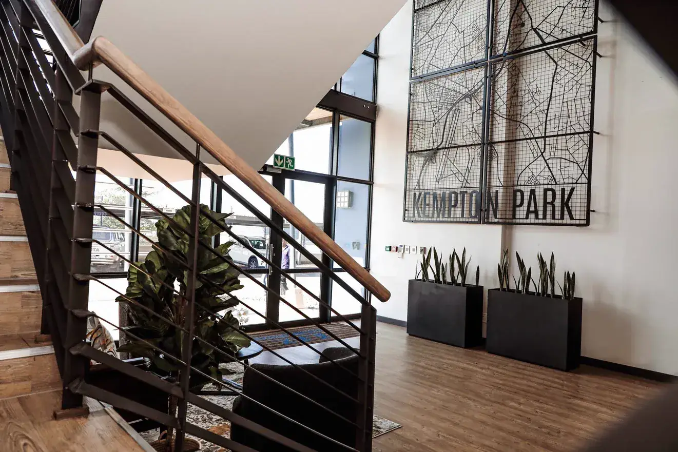 EPX: the double volume lobby with its steel and timber staircase and the Kempton Park wire map artwork.