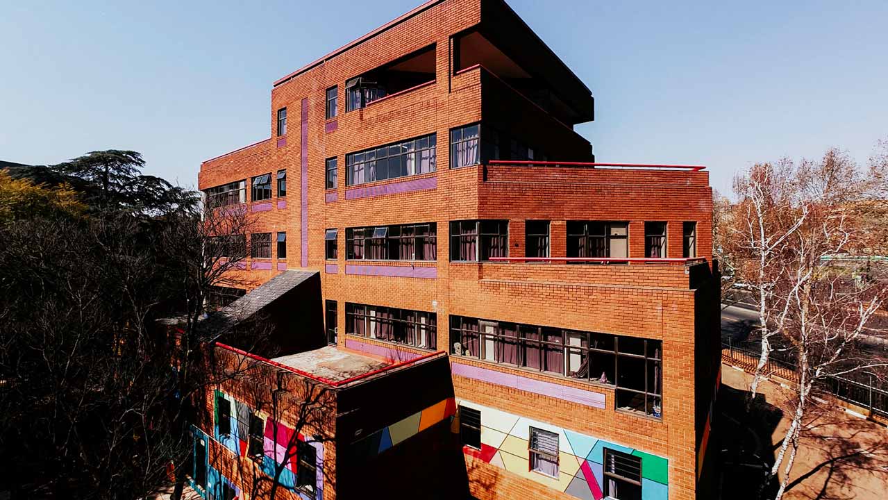 Hillside: the red brick facade with its colourful geometric mural along the lower wall.